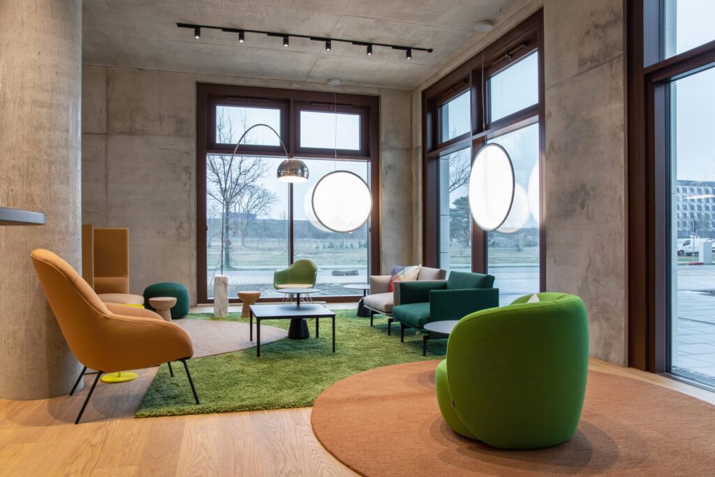 Lounge mit Sesseln und Arbeitsplätzen im ipartment Berlin Airport